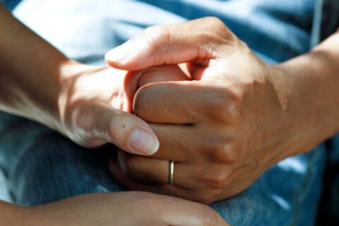Close-up of hands being held and examined for possible nerve symptoms