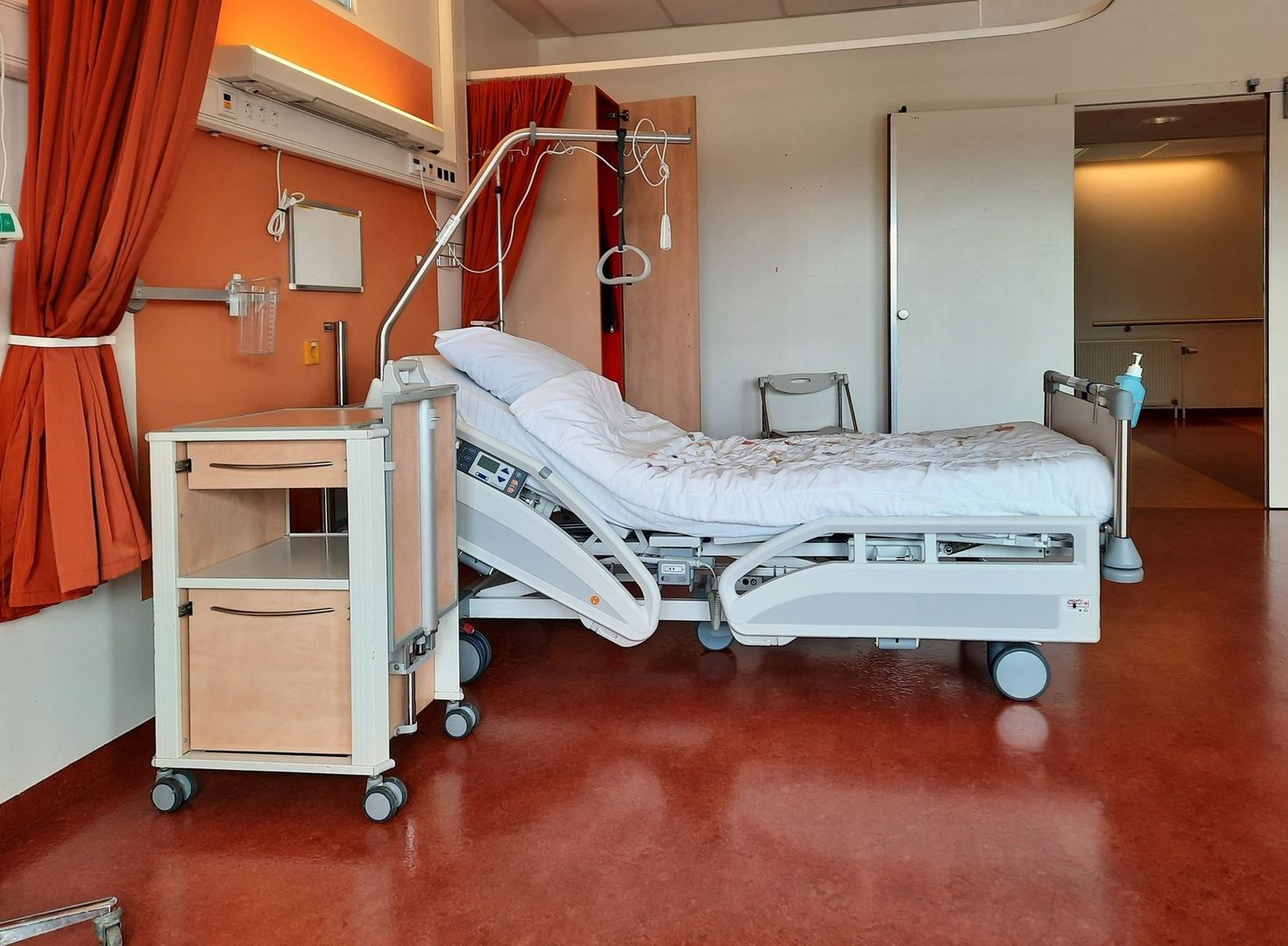 Hospital room with an adjustable bed and bedside clinical equipment